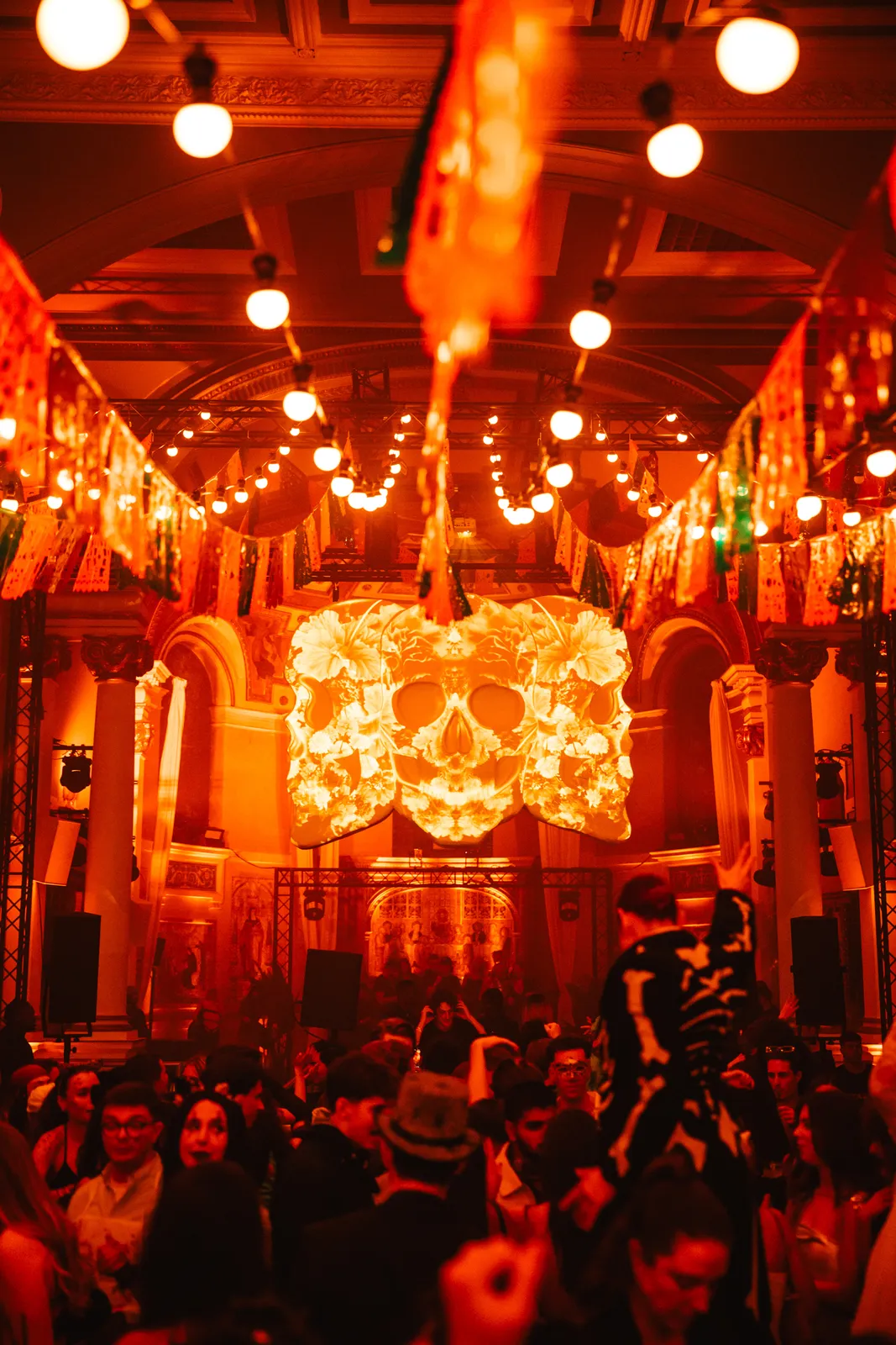 Floral skull installation over a packed hall
