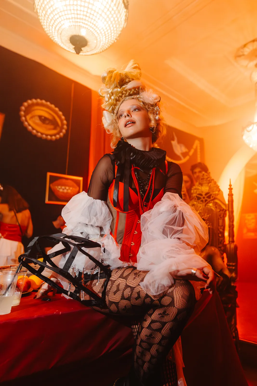 Guest in extravagant costume under chandelier light